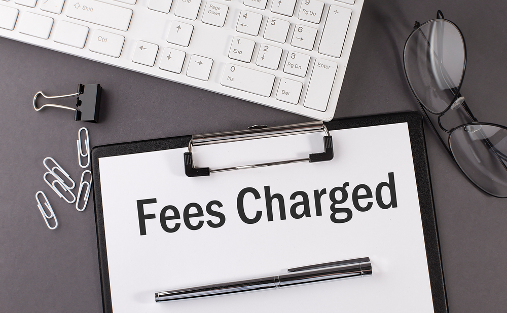 Office paper sheet with text FEES CHARGED and keyboard